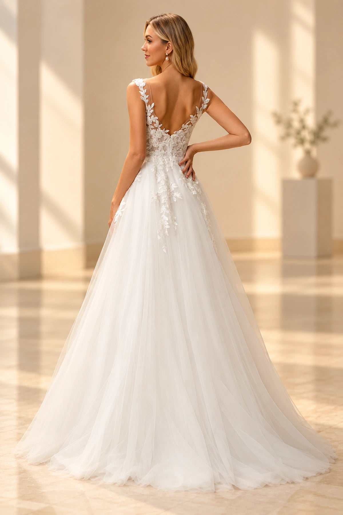 Back view of Vedress lace tulle wedding dress featuring a low V-back, floral applique straps, sheer lace panels and a trailing A-line skirt.